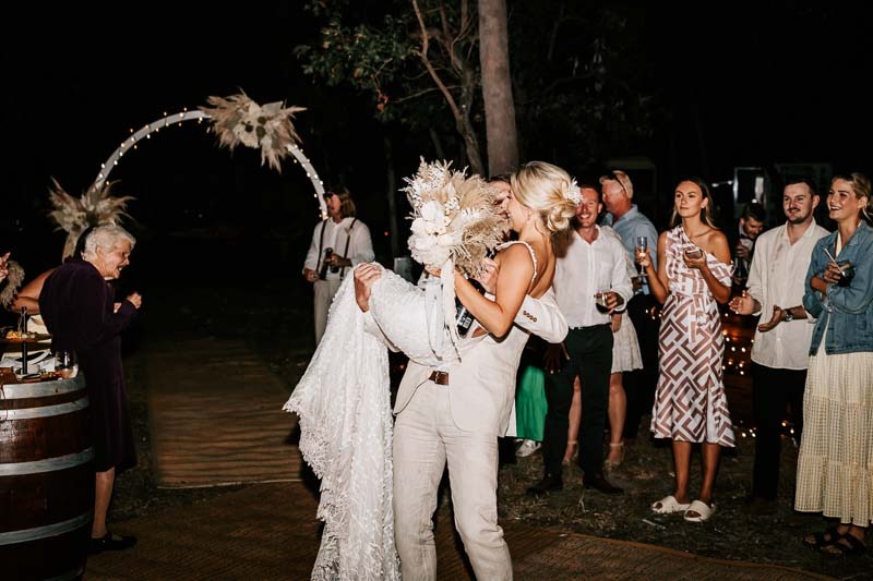 Groom carries Bride into reception