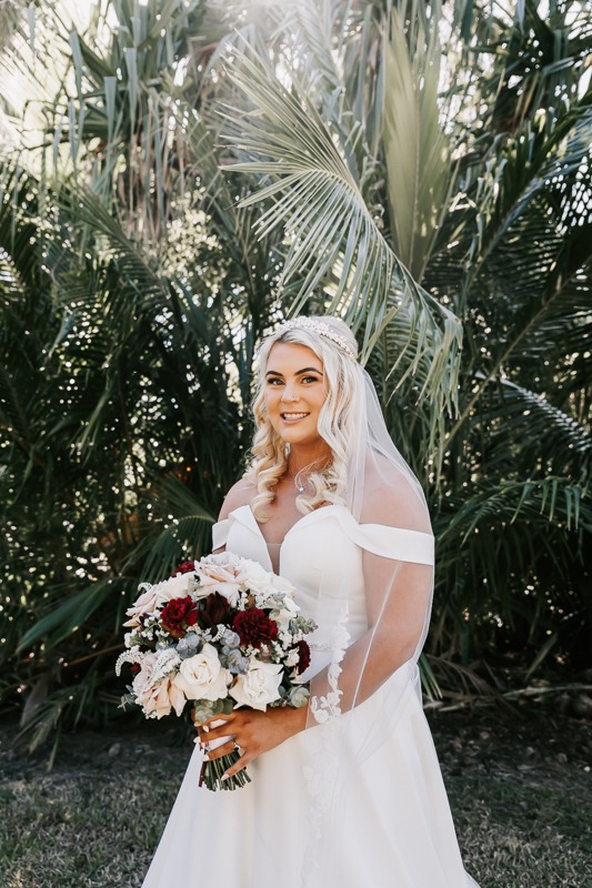 Bride smiles holding bouquet