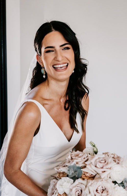 Bride laughs and holds bouquet