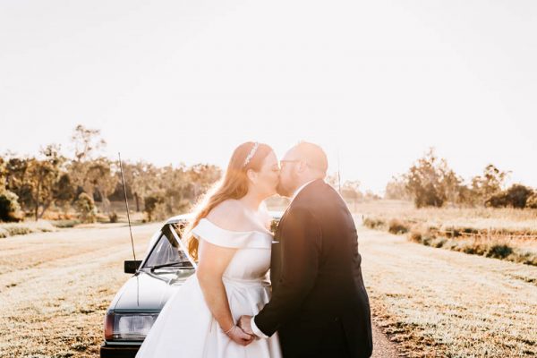 Bride & Groom kiss in front of car