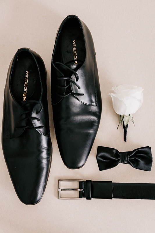 Grooms shoes, belt, tie, and buttonhole