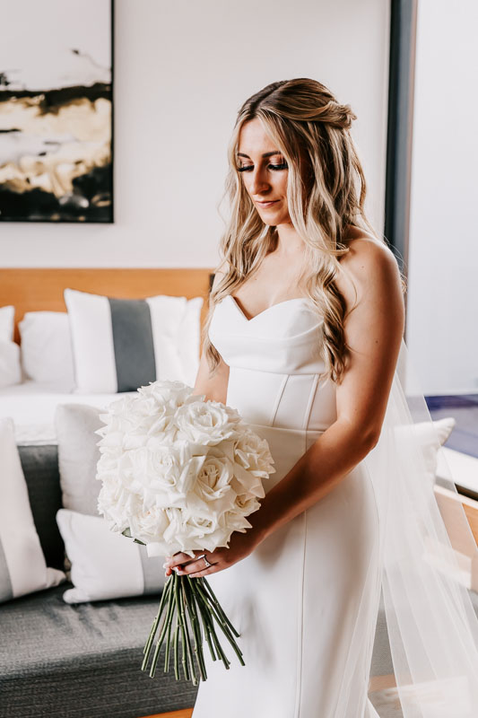Bride looks down at bouquet