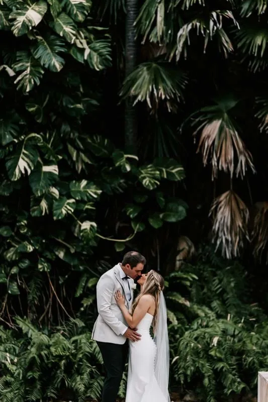 Bride & Groom kiss in formal gardens