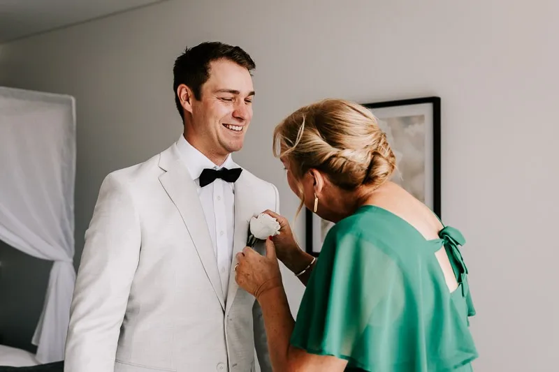 Mother putting buttonhole on Groom