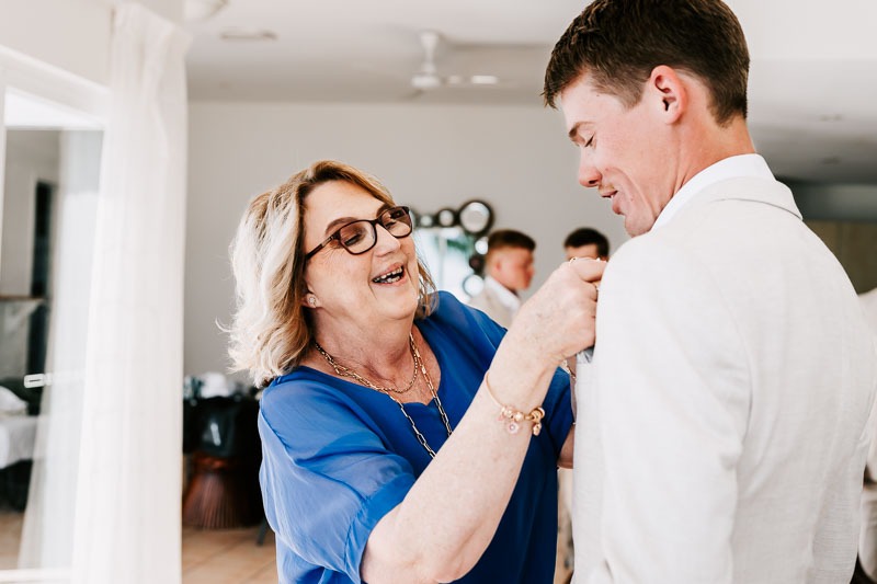 Groom's mother putting on buttonhole