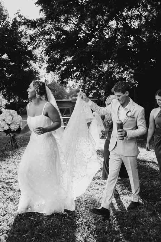 Groom holding brides dress