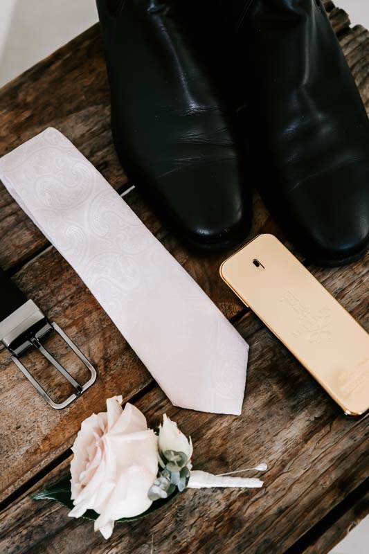Grooms tie, belt, shoes, cologne and buttonhole