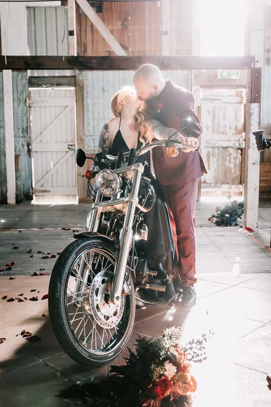 Bride & Groom kiss on motorbike