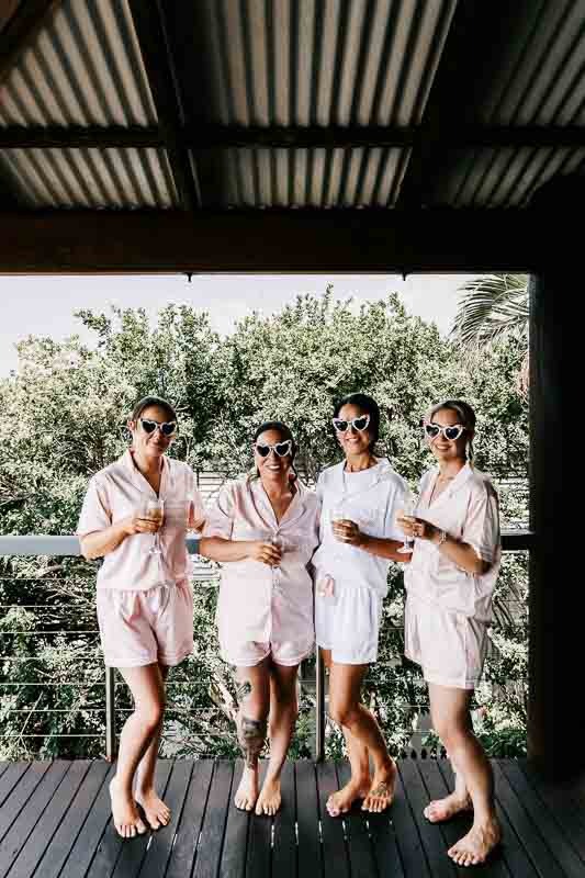 Bride and bridesmaids pose with glasses on