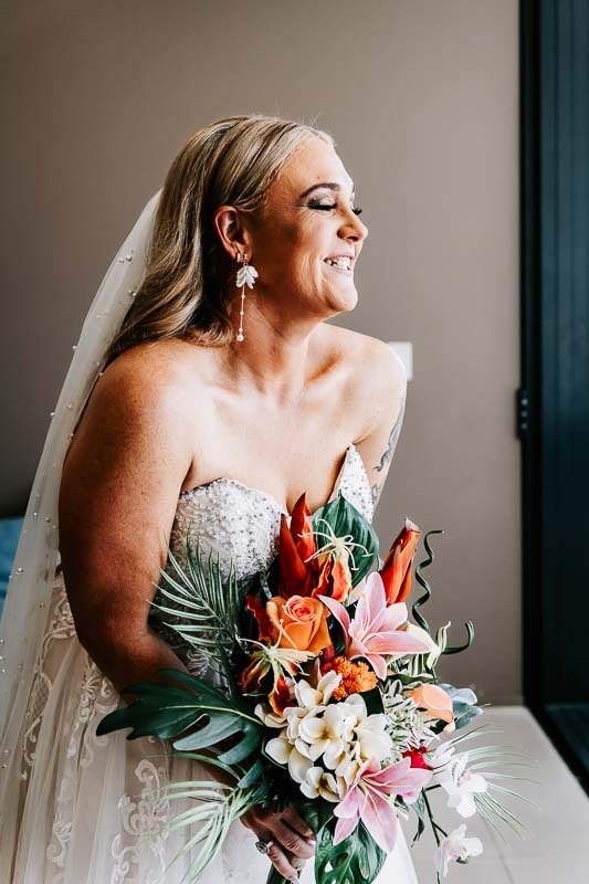 Bride smiling and laughing holding bouquet