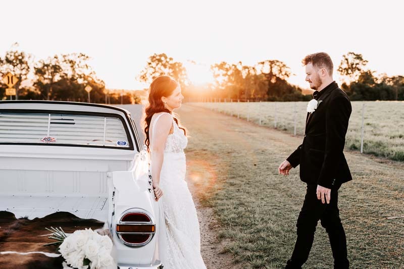 Bride & Groom post with vintage ute at sunset