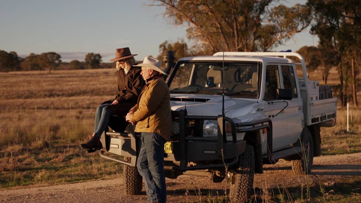 two people waerings drizabone sitting on landcruiser