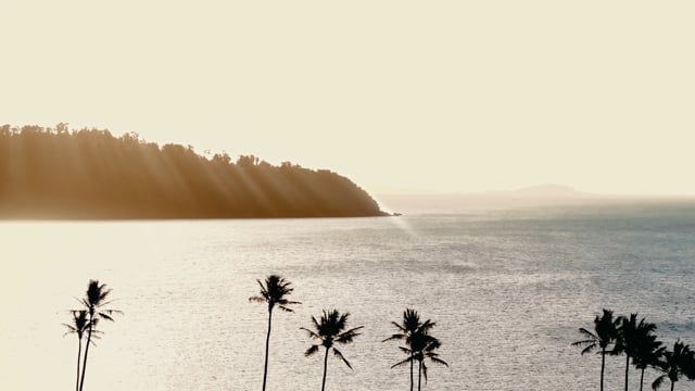 Professional videography, photography, and drone footage of a serene coastal landscape during sunset.