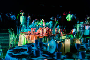 Professional videography, photography, and drone footage of event dining setup with elegant tables and colorful lighting