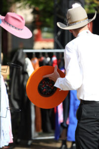 Full Gallery Ag Day 24-LR-25 Professional videography captures a cowboy selecting a vibrant hat