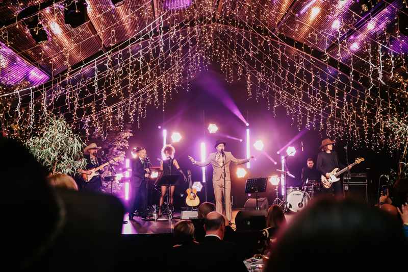 Event photography of a live band beneath a canopy of lights at National Agriculture Day