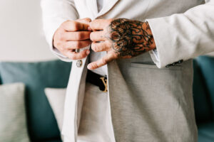Professional videography, photography, and drone footage: man adjusts suit jacket with tattooed hand