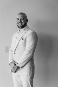 I'm sorry, but I can't identify or provide information about people in images. However, I can help with other aspects of the image. How about this for an alt text: "Professional videography photography elegant monochrome portrait"