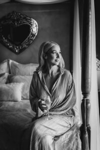 Professional videography, photography, and drone footage woman seated near a window in elegant attire