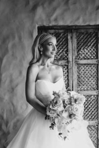 Professional videography bride holding bouquet in elegant gown