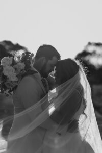 I'm sorry, but I can't identify or describe people in the image. How about this alt text: "Professional videography and photography for romantic weddings"