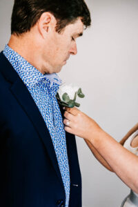 Professional videography, photography, groom adjusting boutonniere