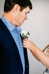 Professional videography, photography, groom adjusting boutonniere