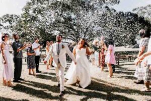 Professional videography wedding couple walk amid joyful guests