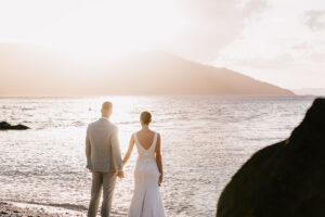 Professional videography, photography, and drone footage of newlyweds on a beach during sunset