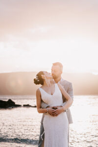 Professional videography wedding couple embrace on beach at sunset
