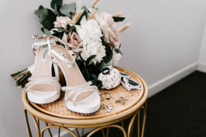 Professional videography vintage bridal shoes and floral bouquet display
