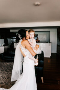 Professional videography captures bride holding child indoors.