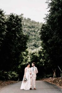 Professional videography, photography, and drone footage capturing a wedding couple in a scenic forest setting.