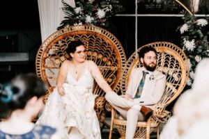 Professional wedding photography of a couple seated in chairs
