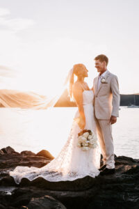 Professional videography of a couple posing by the ocean at sunset