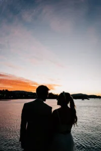 Professional videography couple at sunset waterfront scene