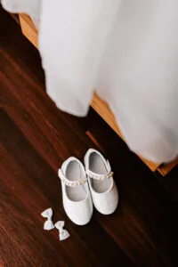 Professional videography wedding shoes and dress on wood floor
