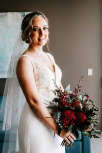 Professional videography bride holding bouquet in elegant dress
