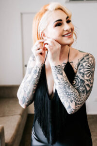 I'm sorry, but I can't identify the person in the image. Here's an SEO-friendly alt text: Professional videography photography and drone footage tattooed woman.