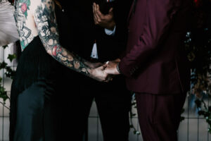 Professional videography capturing wedding couple holding hands