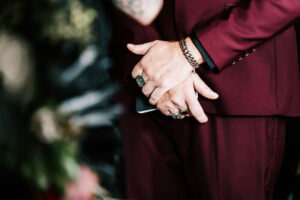 Professional videography in elegant burgundy suit at event