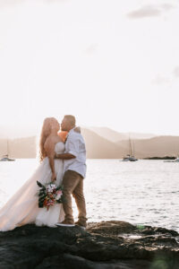 Professional videography and photography couple kissing by the sea