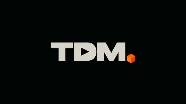 New TDM logo with orange cube on a black background, from the 2025 showreel