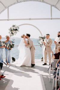 Professional videography, photography, and drone footage of a wedding ceremony by the sea.