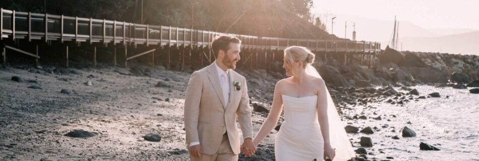 Professional videography couple walking on a serene beach setting