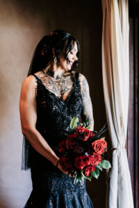 Professional videography bride in black gown with rose bouquet