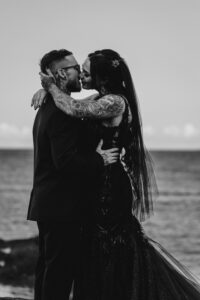 Professional videography couple in romantic seaside embrace