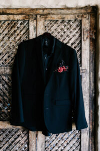 Professional videography, photography, dark suit on rustic door