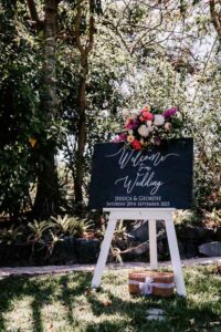 Professional videography for outdoor wedding sign and flowers