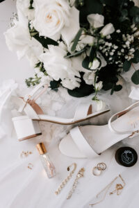 Professional videography, photography, and drone footage of wedding accessories with floral bouquet.